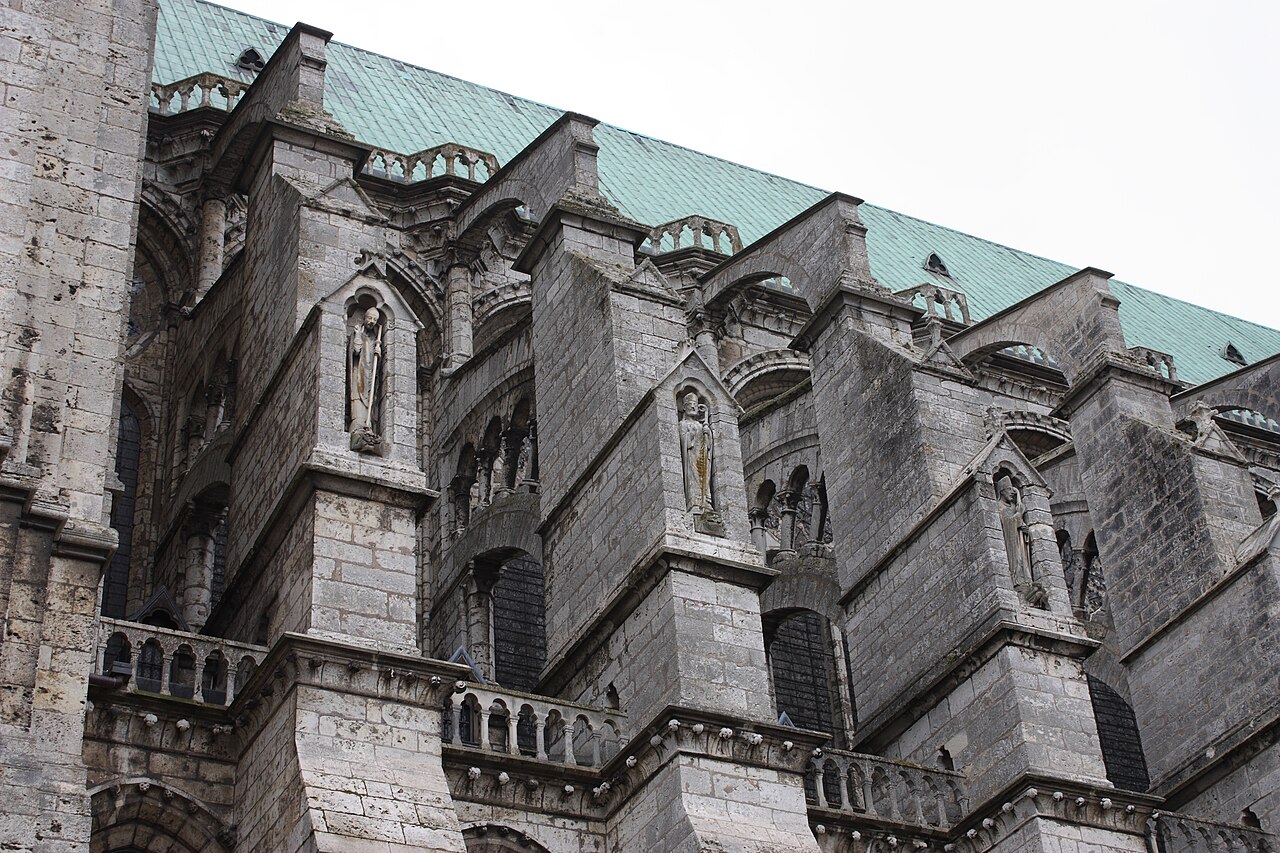 Vista diagonal de los arbotantes de Chartres: arcos que enlazan los contrafuertes exteriores con el muro alto de la nave, dejando huecos por debajo.