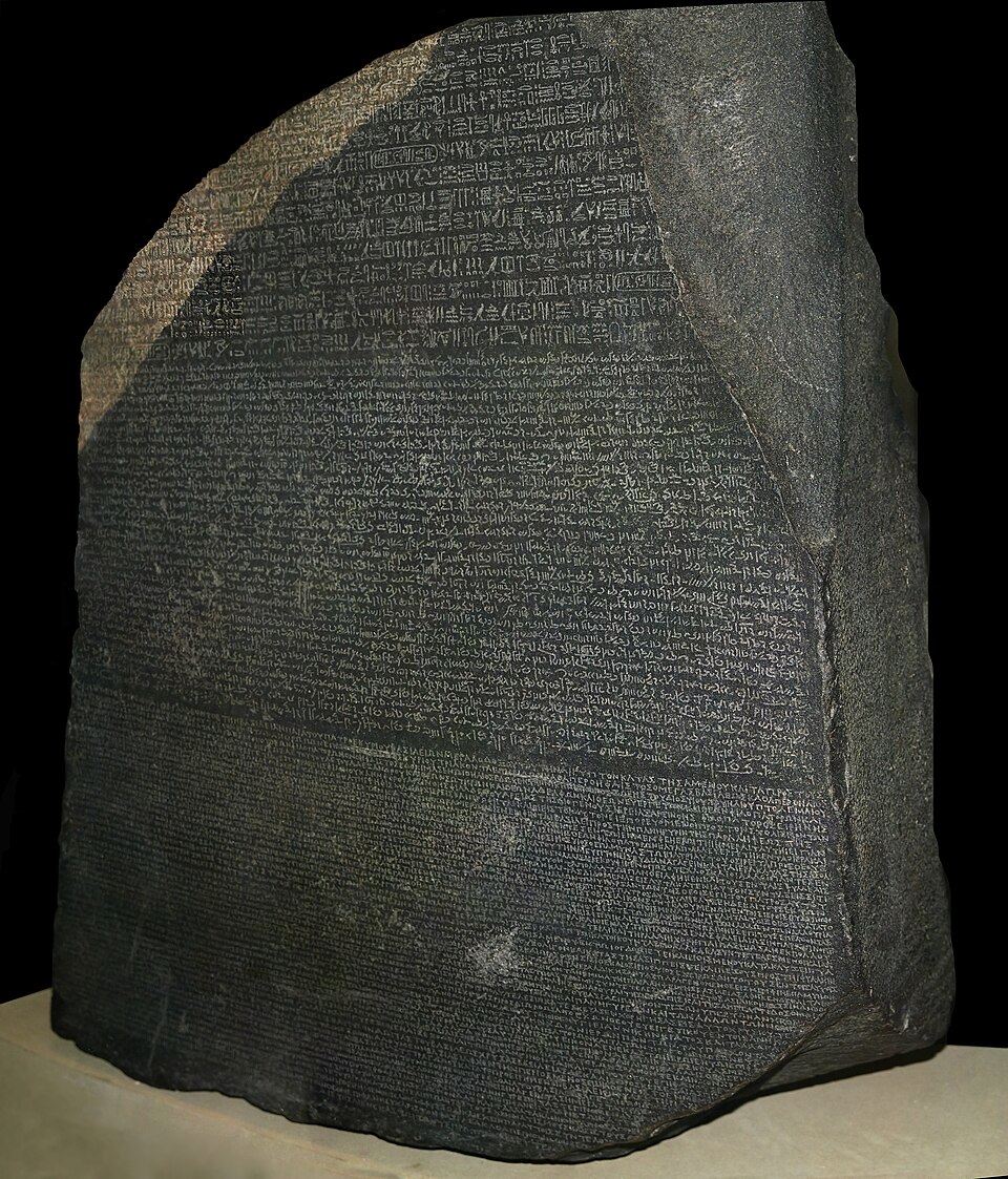 Piedra de Rosetta con tres bloques de inscripción: jeroglíficos en la parte superior incompleta, demótico en el centro y griego en la parte inferior.